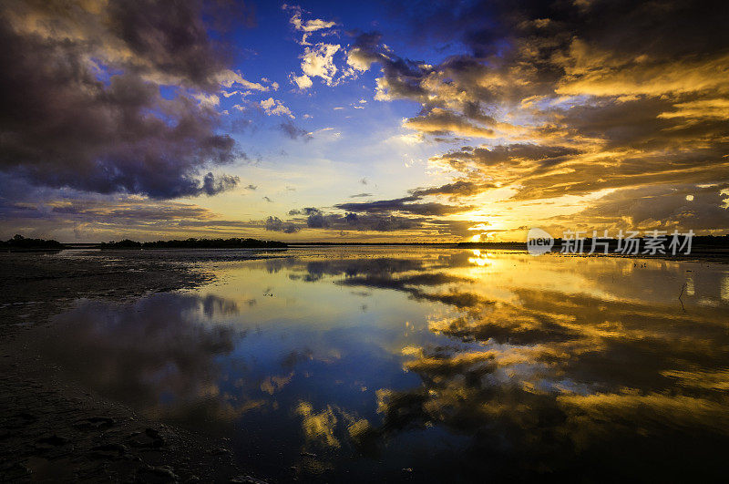 日出时海岸泻湖上戏剧性的天空反射