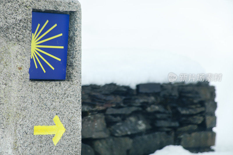圣地亚哥卡米诺雪景里程碑，黄色箭头，扇贝标志。
