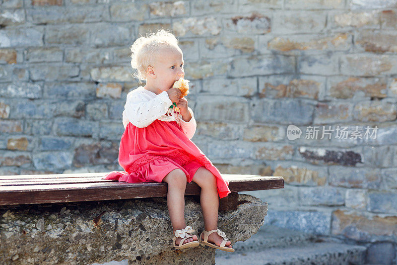 小女孩在长凳上吃面包