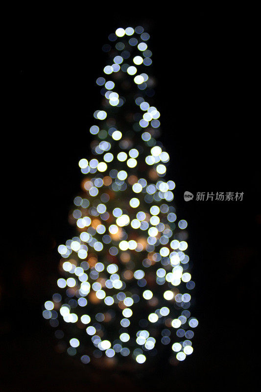 散焦圣诞树的形象，白色的led童话灯，夜晚的背景，散焦