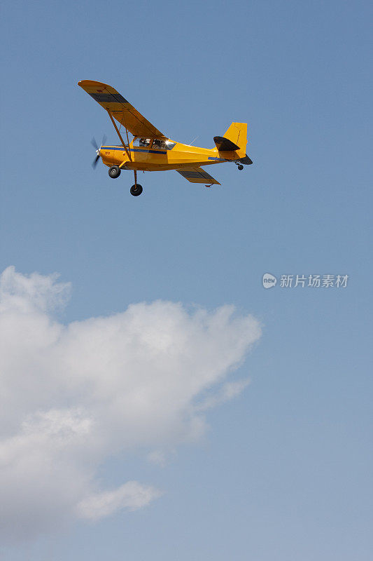 黄色的小飞机在云层上翱翔