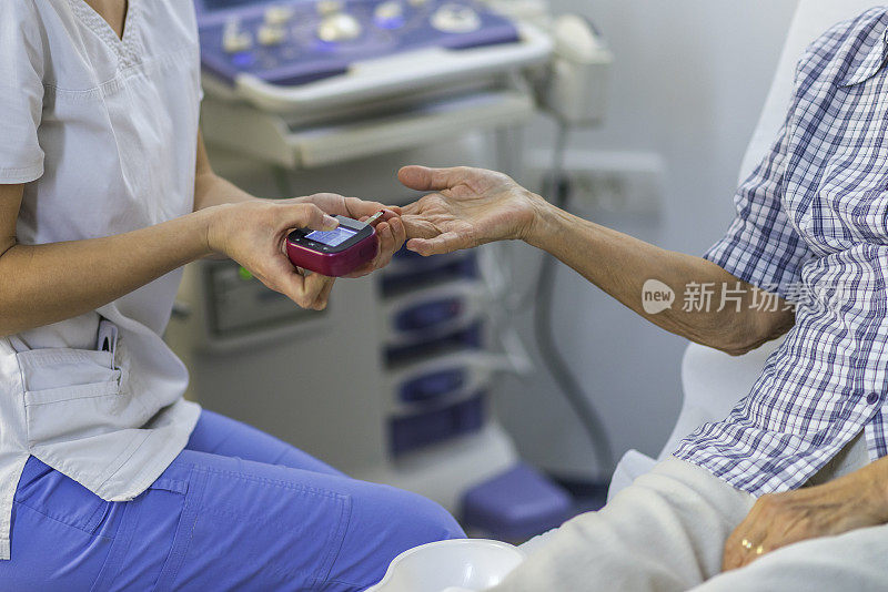 护士正在给一位老年妇女做血糖检查