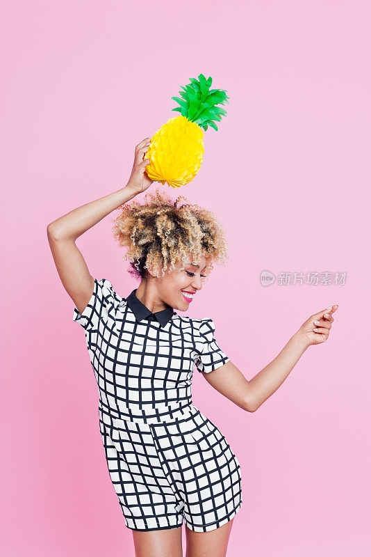 美国黑人年轻女子拿着菠萝蜂窝装饰