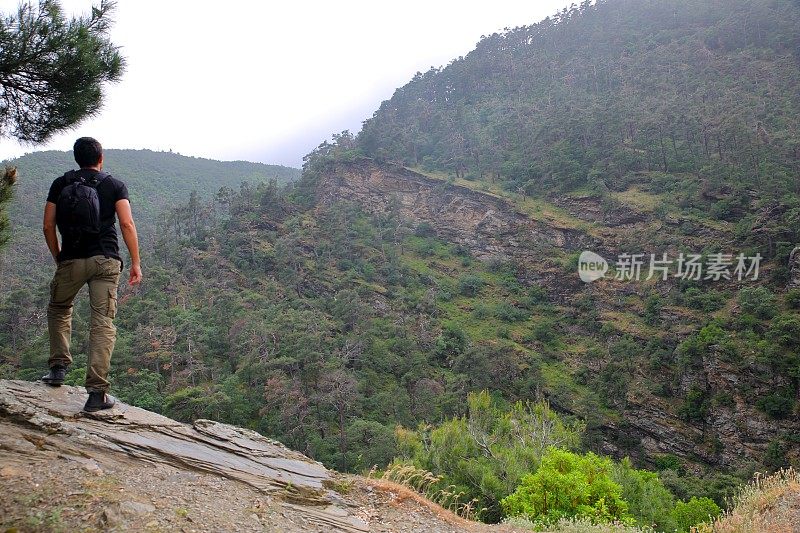 男背包客站在山顶。