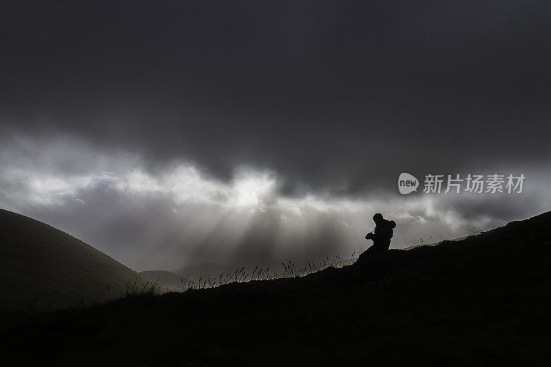 摄影师看着相机在戏剧性的风景