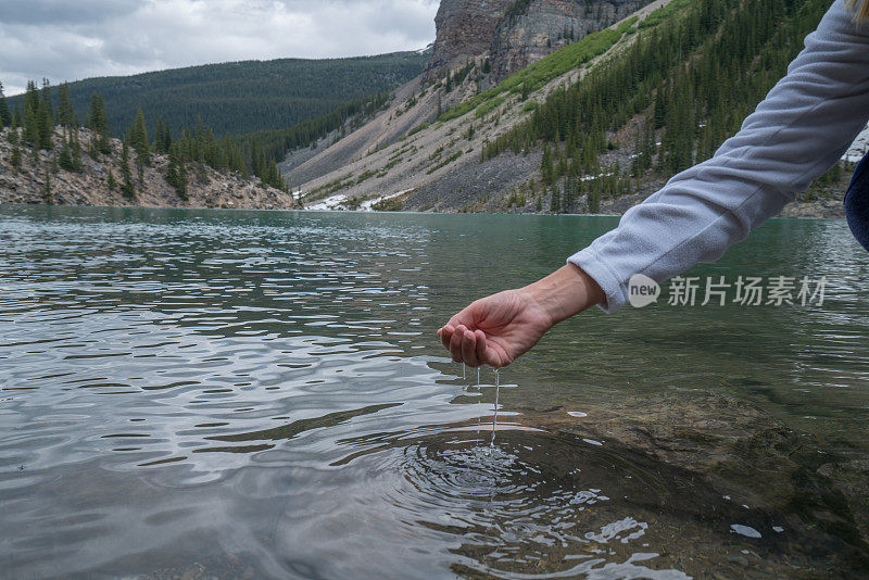 人们用手从山上的湖泊中舀取淡水