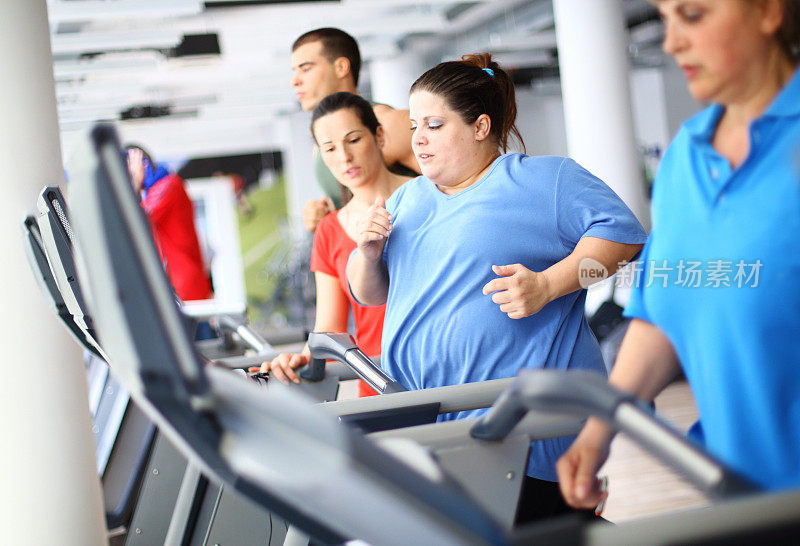 在跑步机上锻炼的超重女性。
