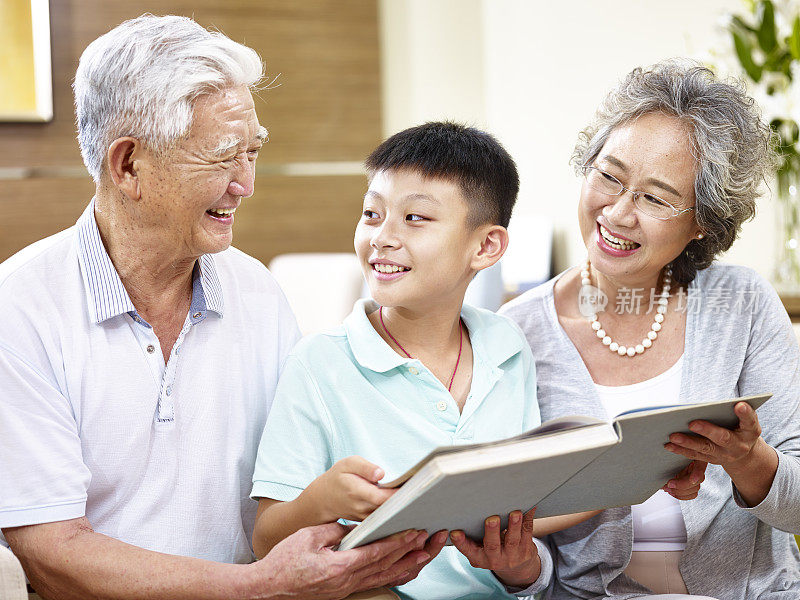 亚洲祖父母和孙子一起看书