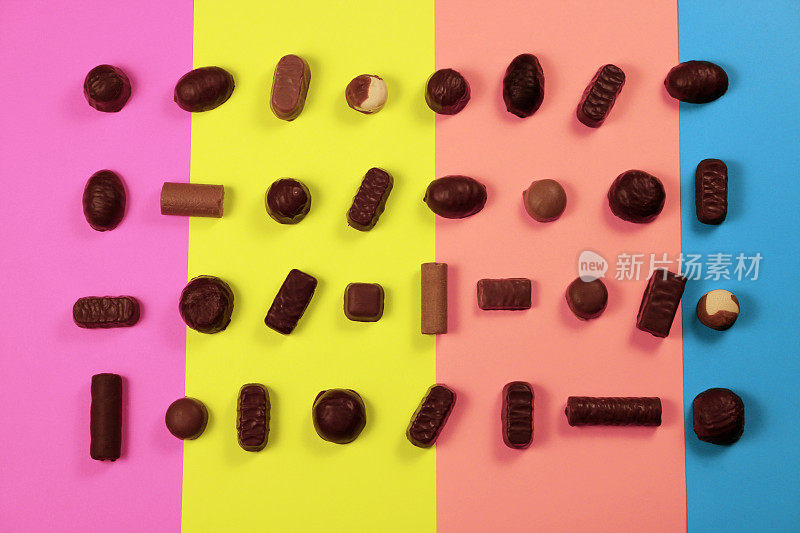 巧克力糖果在多色背景，俯视图