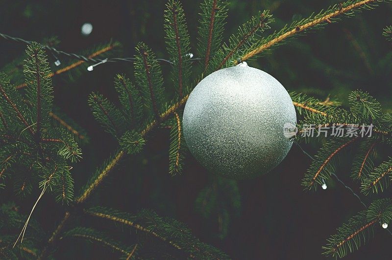 一个银光闪闪的装饰品在圣诞树上的特写-柔和的焦点