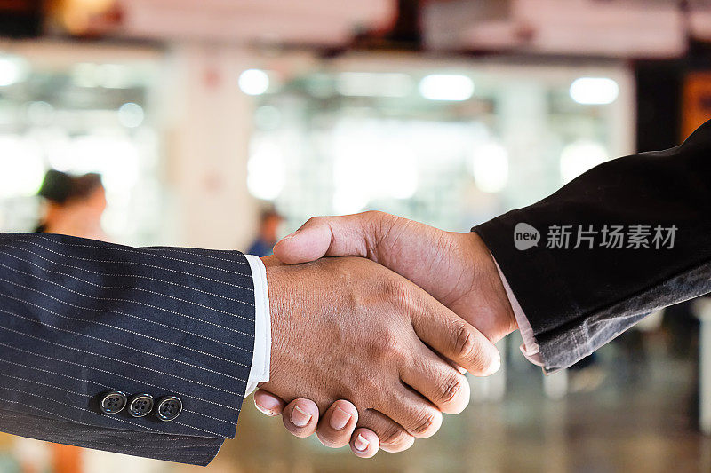 收购业务合作伙伴握手结束会议的特写镜头。