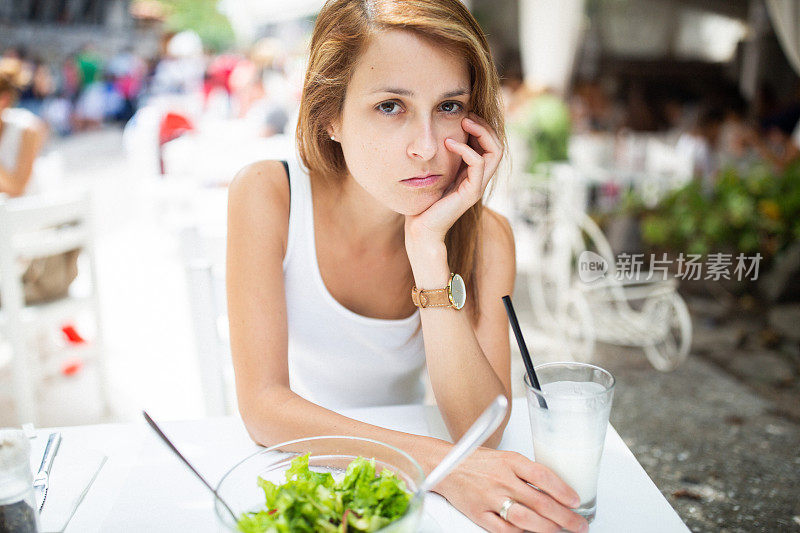 抑郁症妇女节食吃绿色沙拉在餐厅