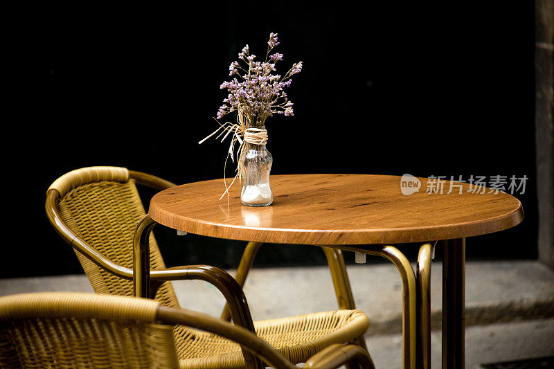 人行道上的咖啡馆露台上装饰着花瓶和鲜花。