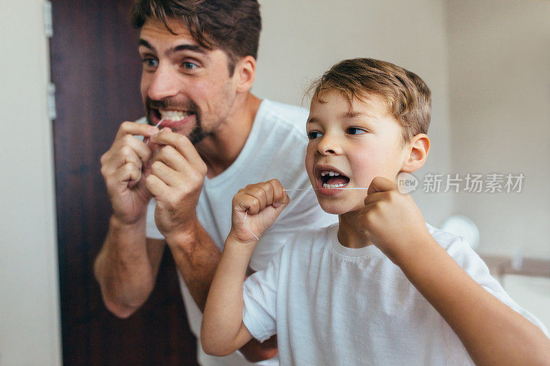 父子俩用牙线清洁牙齿