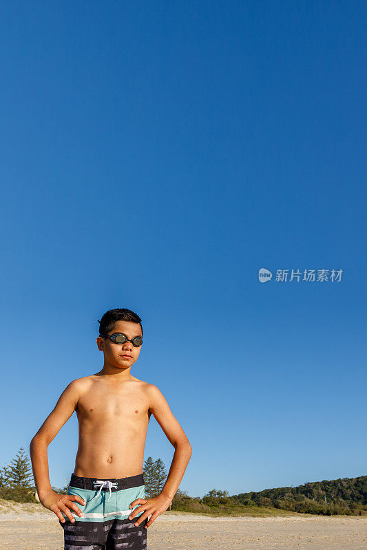 澳大利亚土著男孩与冲浪板在海滩上