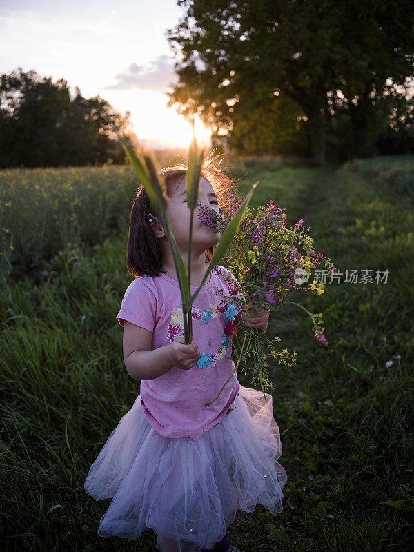 在瑞士闻着夏日鲜花的小女孩