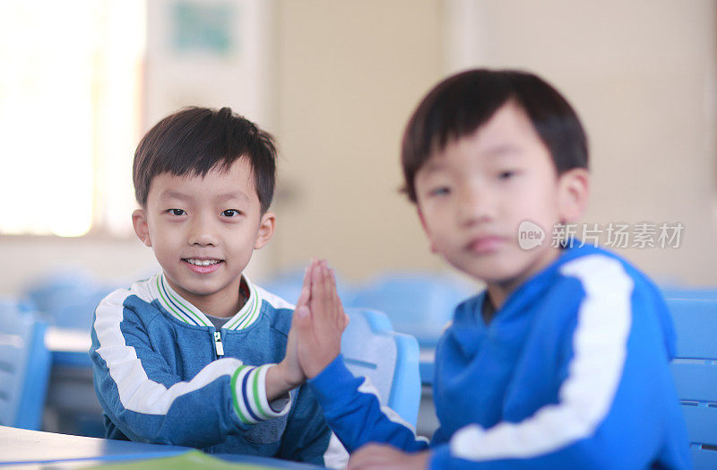 小男孩在教室里的书桌前读书