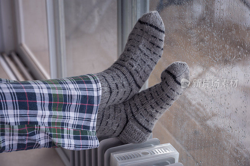 近距离图像的女人的脚散热器加热器在雨季的冬天。