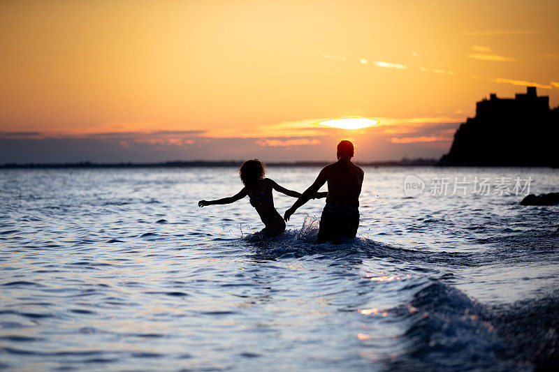 成人夫妇在海边享受日落-股票照片