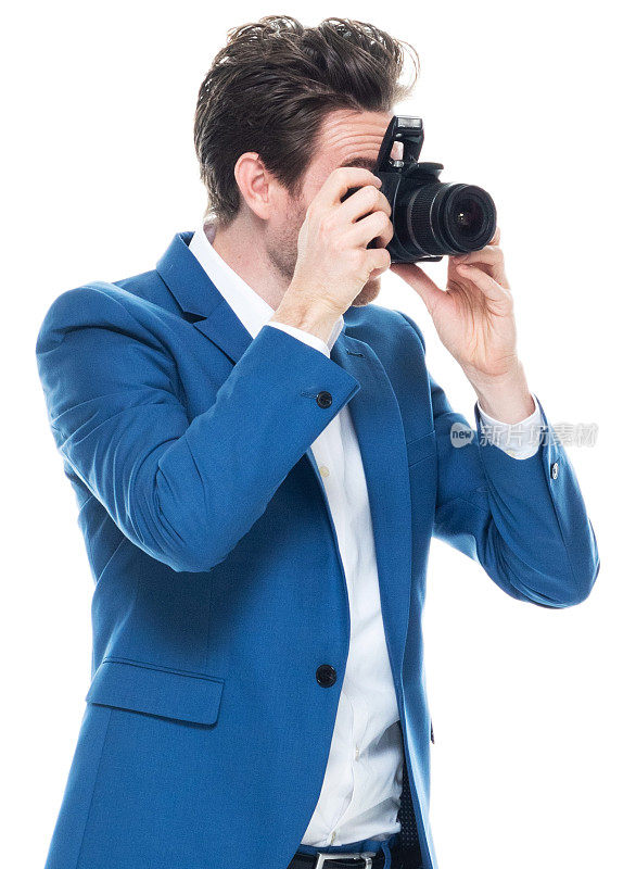 白人年轻男性摄影师站在白色背景穿着智能休闲和拿着相机