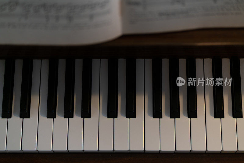 钢琴键和古典音乐书的特写