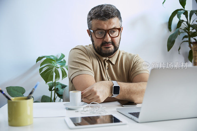 一个年轻人在他的家庭办公室里对着电脑说话