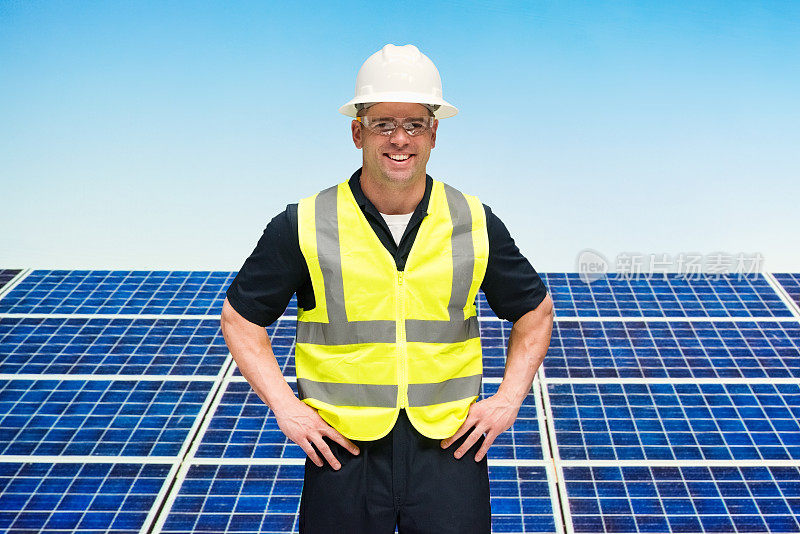 白人男性建筑承包商在太阳能发电站谁是户外戴安全帽和支持太阳能电池板