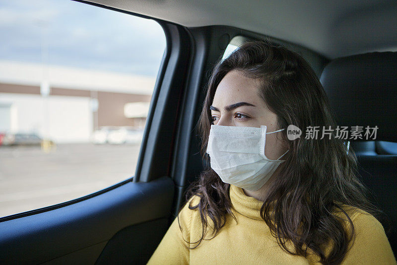 车内的年轻女子戴着防护面罩