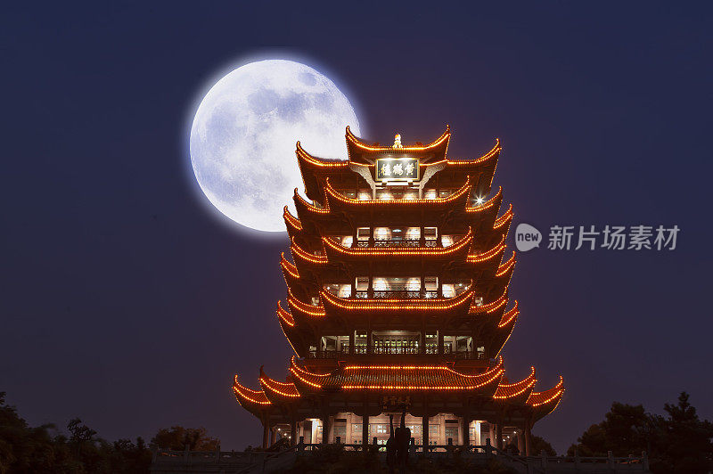 中秋节的夜晚灯火辉煌的黄鹤楼上挂着一轮明月