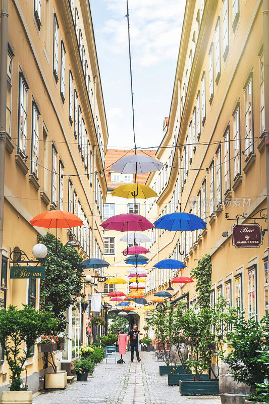 维也纳古老的通道街道上挂着五颜六色的雨伞