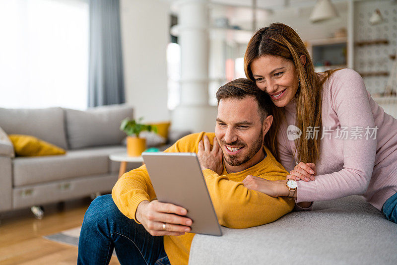 相爱的夫妇在家里用平板电脑玩得很开心