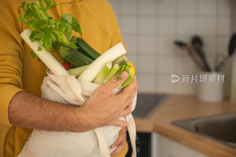 男人把蔬菜放在厨房里