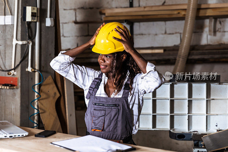 这是一位女木匠在她的工作室里使用笔记本电脑的照片