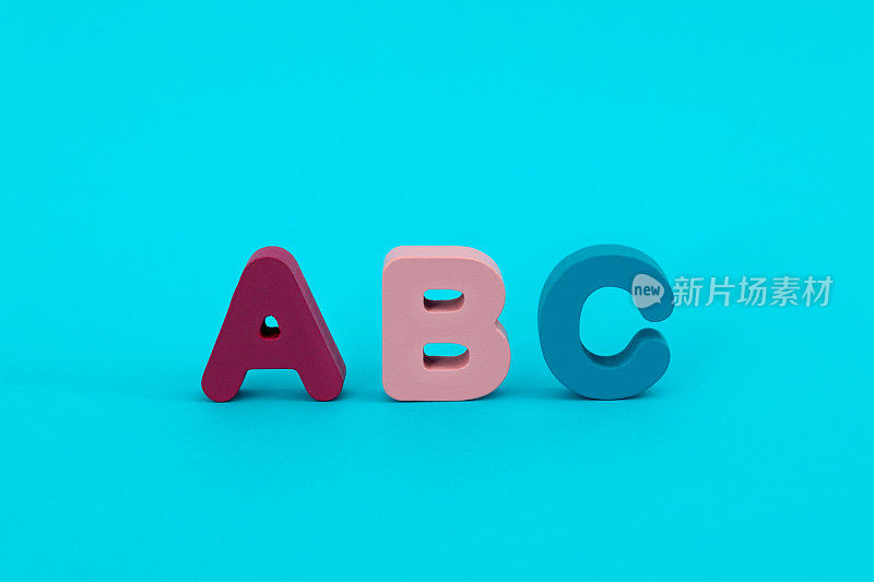 蓝色背景上的木制大写字母A、B、C