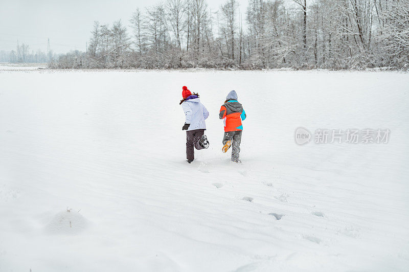 两个小女孩在雪地上奔跑