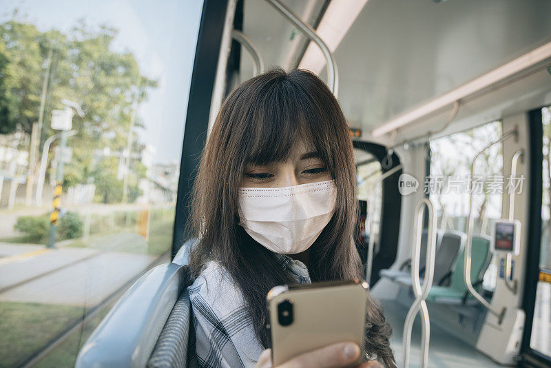 年轻女子在乘坐地铁时使用智能手机