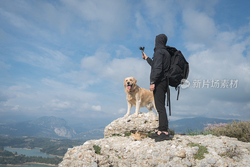 旅行者和他的狗在大自然中用万向节拍摄。