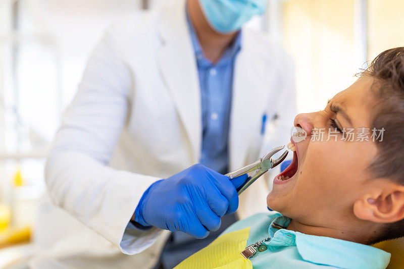 男牙医正在用牙钳拔牙。医学、牙科、卫生符号。