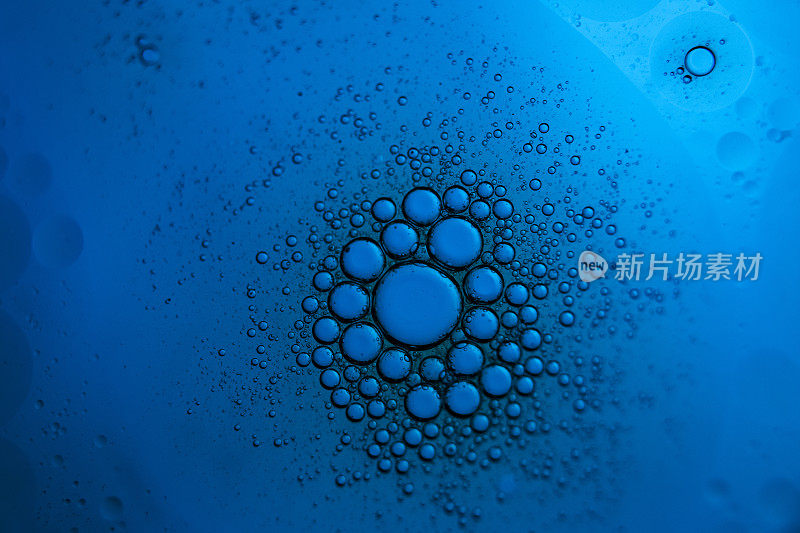 小气泡聚集在蓝色背景中心的大气泡周围