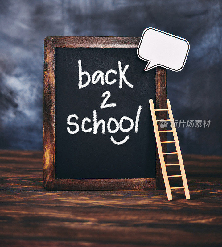 写有“回到学校”信息和梯子的黑板
