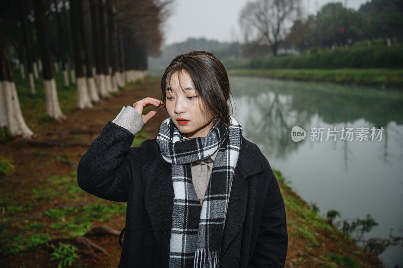 亚洲女孩走在河边的雨天