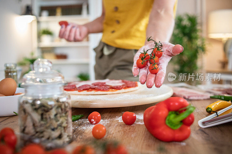 一位年轻女子正在家里准备披萨。网上食谱和食物准备。