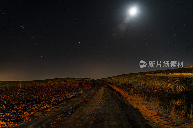 满月和星空下乡村乡村道路的夜景