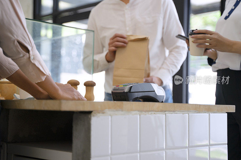 顾客正在面包店和咖啡café通过电子支付支付。