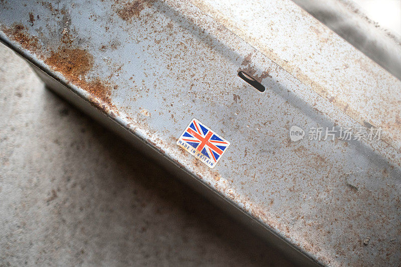 使用良好，风化生锈的金属工具箱，上面有一个旧的“英国制造”标签。