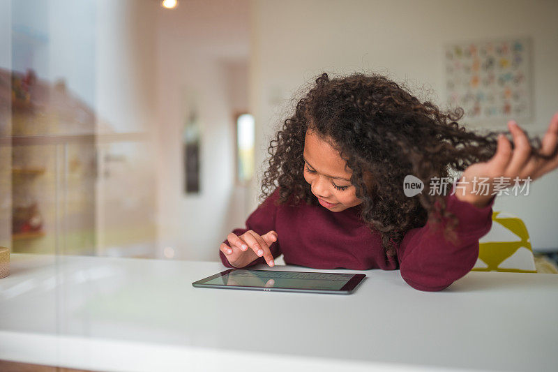 梳着非洲式发型的可爱女孩正在使用平板电脑