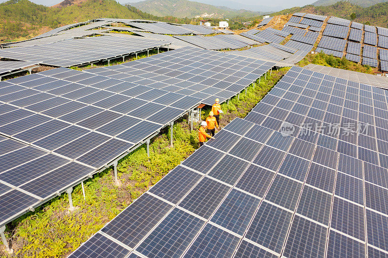 三名技术人员边走边检查太阳能电池板