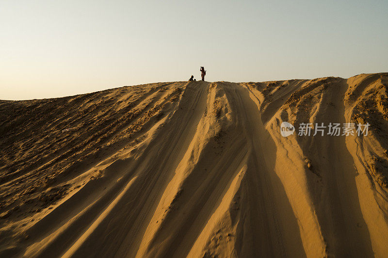 印度拉贾斯坦邦塔尔沙漠沙丘上的汽车轮胎印。游客们开车来到沙漠观看日出，这是一项非常受游客欢迎的活动。