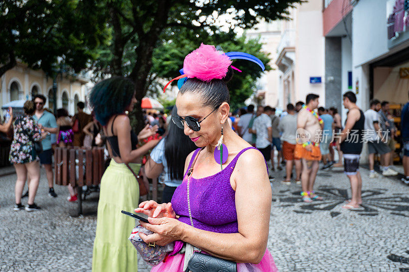 一个穿着狂欢节服装的女人在手机上打字