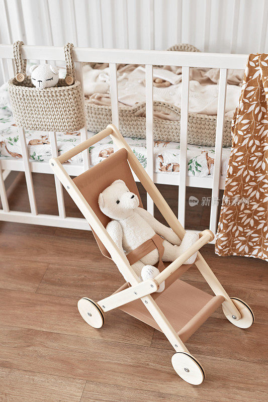 儿童益智木制玩具。育婴室装饰。斯堪的纳维亚风格的游戏室。木推车。婴儿床